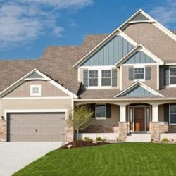 very large suburban home with manicured lawn