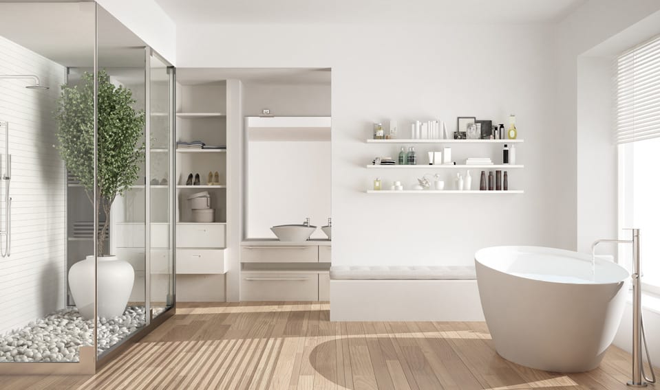 A modern bathroom featuring light wood floors, white walls, a freestanding tub, and a glass shower enclosure.